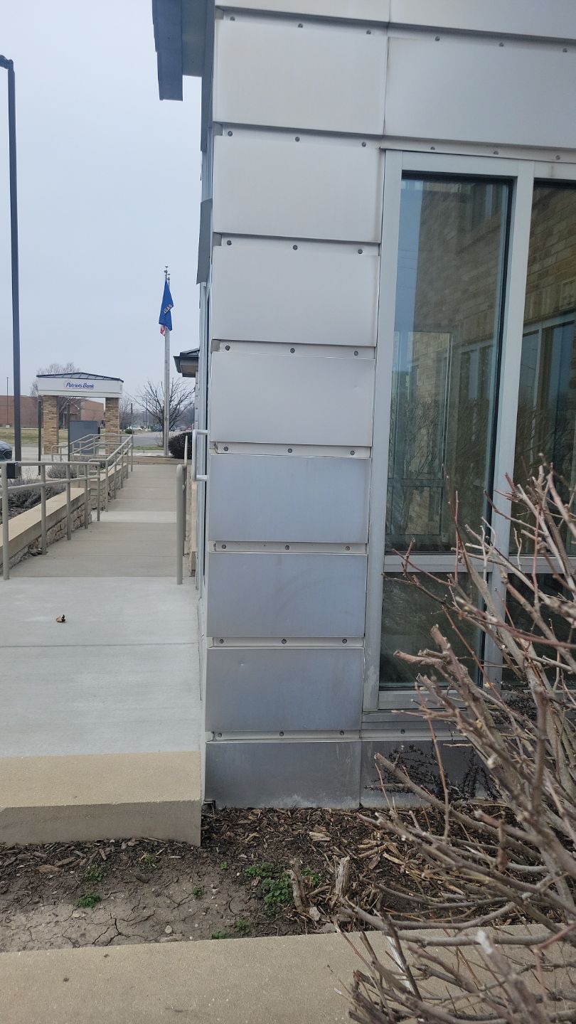 Exterior view of building with metal paneling, ramp, and flag.