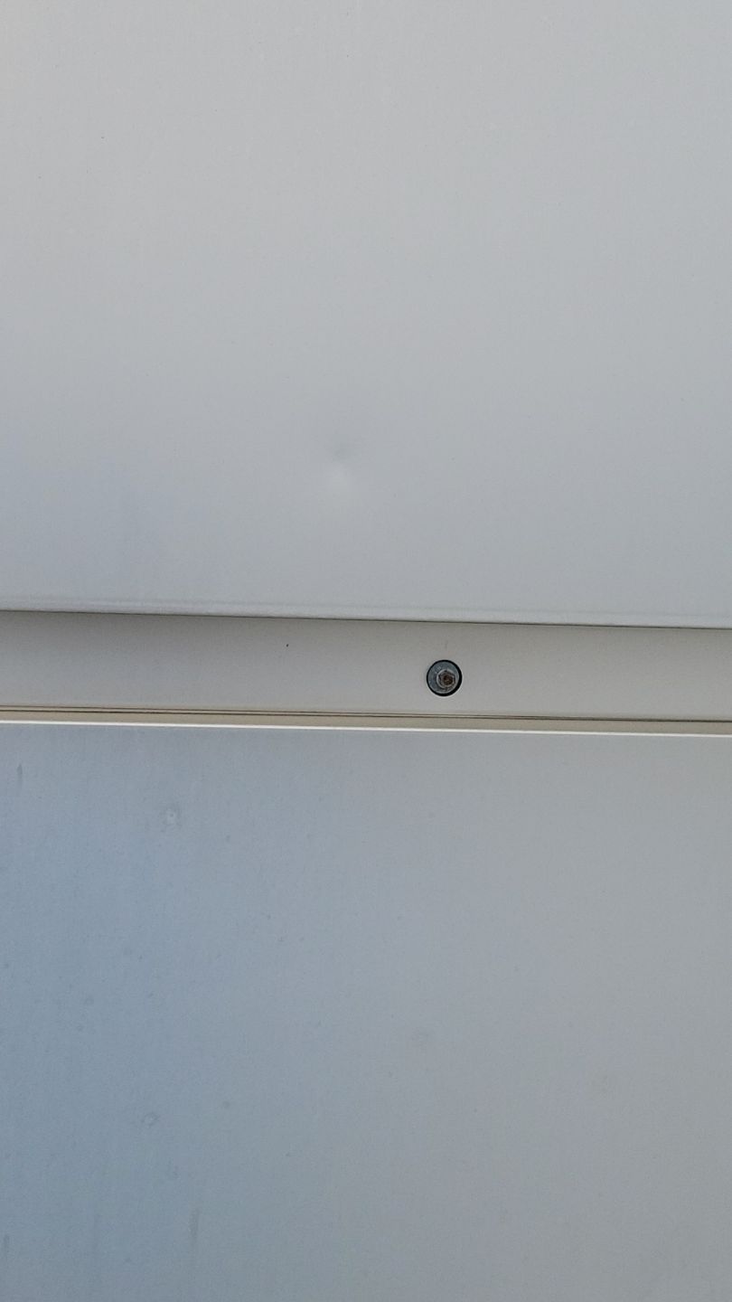 White panels joined with a screw. Small dent in the top panel.