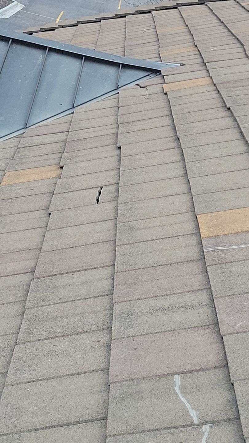Roof with gray shingles and dark metal flashing.