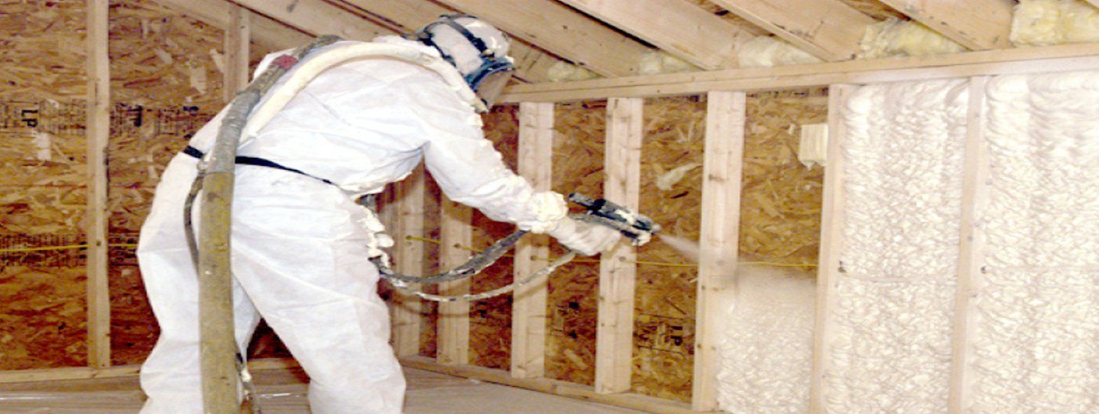 Man applying insulation on wall