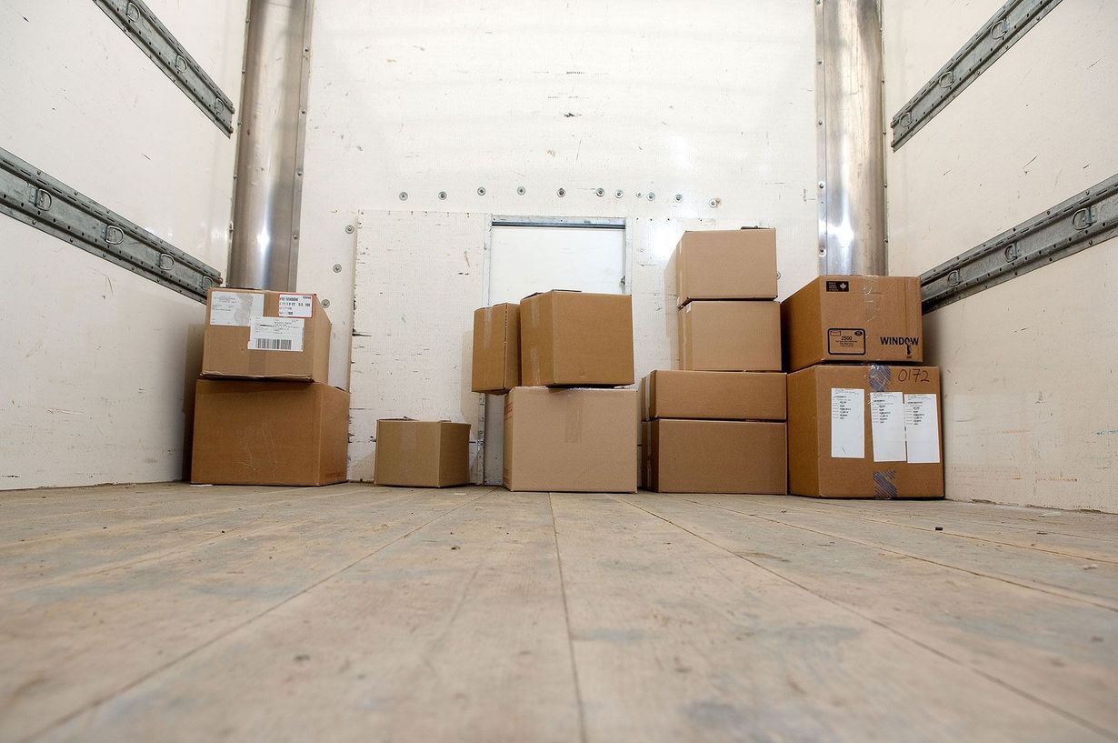 Interior of a truck filled with stacked cardboard boxes, ready for transport.