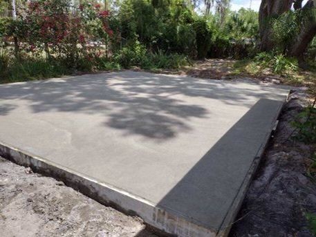 side view of backyard large tree and  semi finished concrete