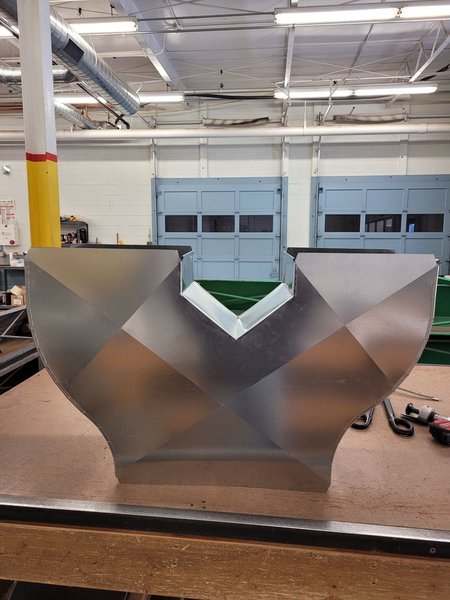 A large metal object is sitting on a table in a warehouse.