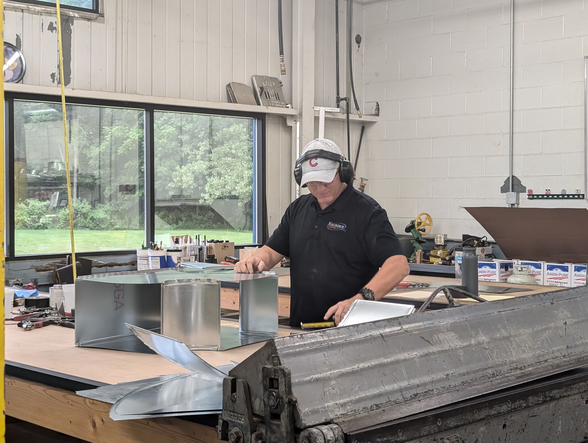 A man is working on a piece of metal in a factory.