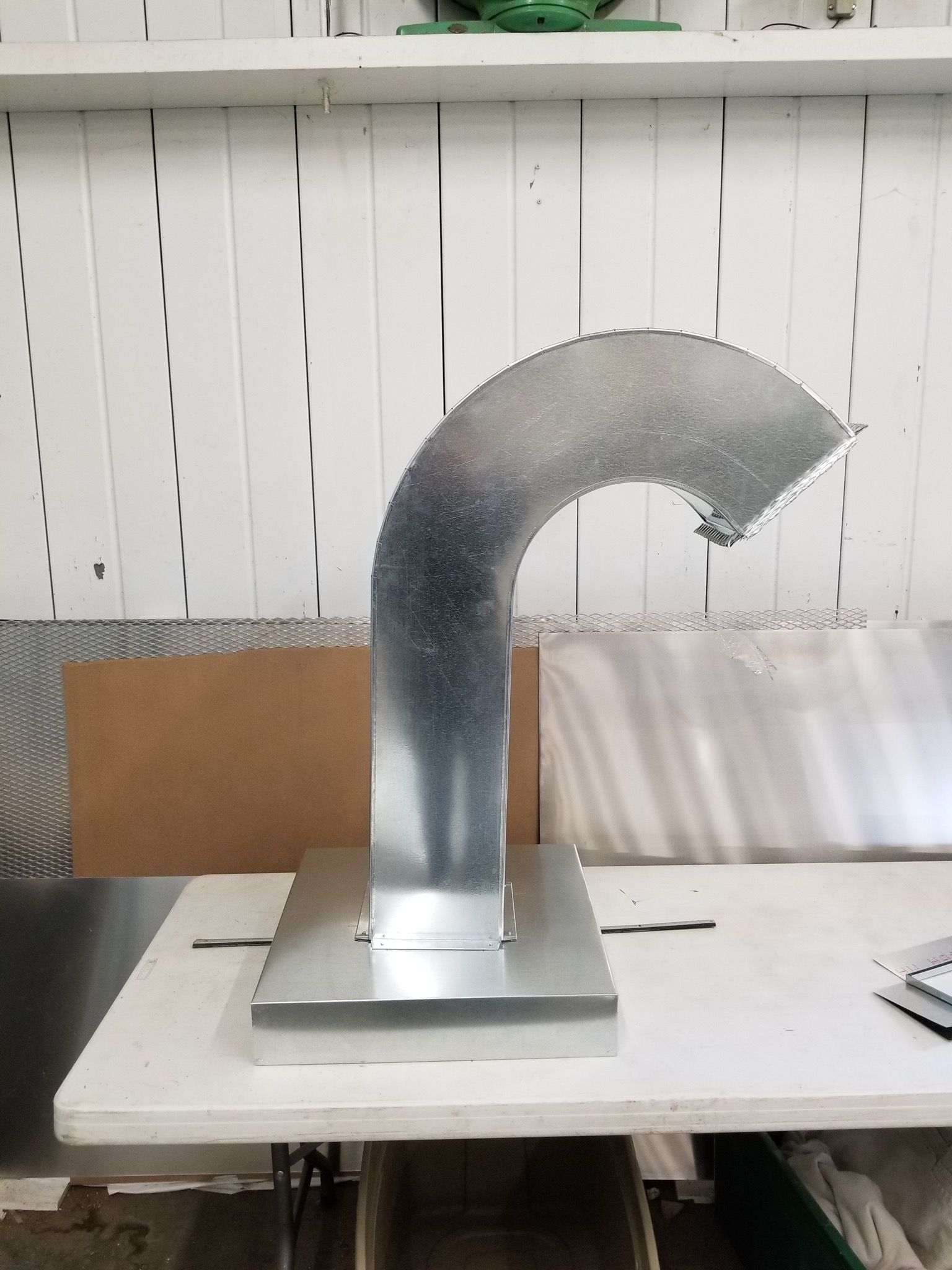 A metal pipe is sitting on top of a white table