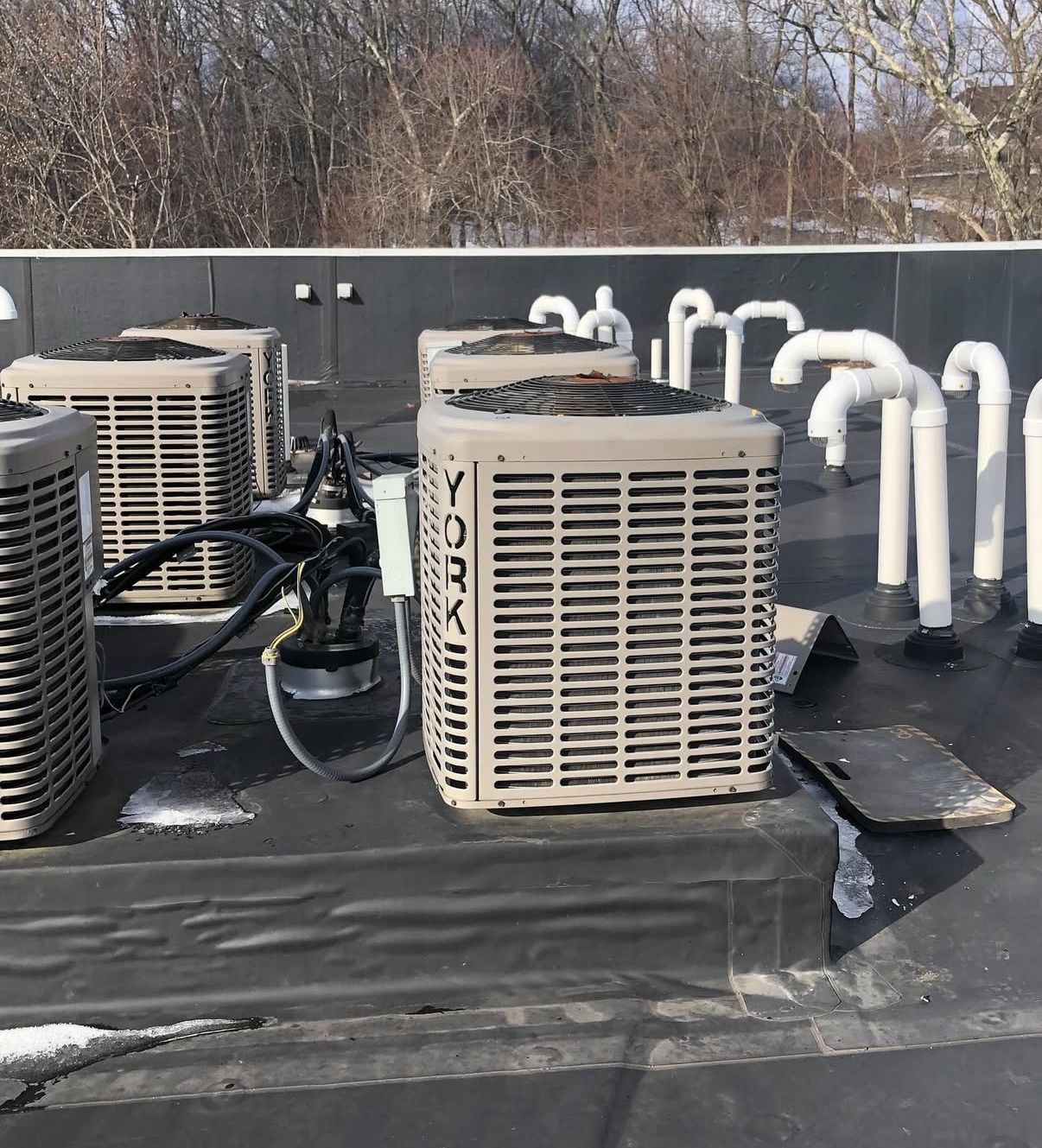 Multiple York HVAC air conditioning units positioned on a flat, black-roofed building