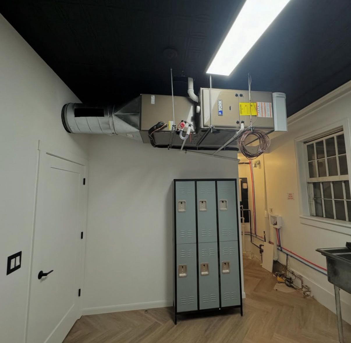 HVAC unit suspended from a black ceiling 