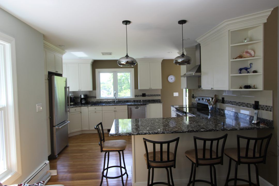 A kitchen with white cabinets and granite counter tops
