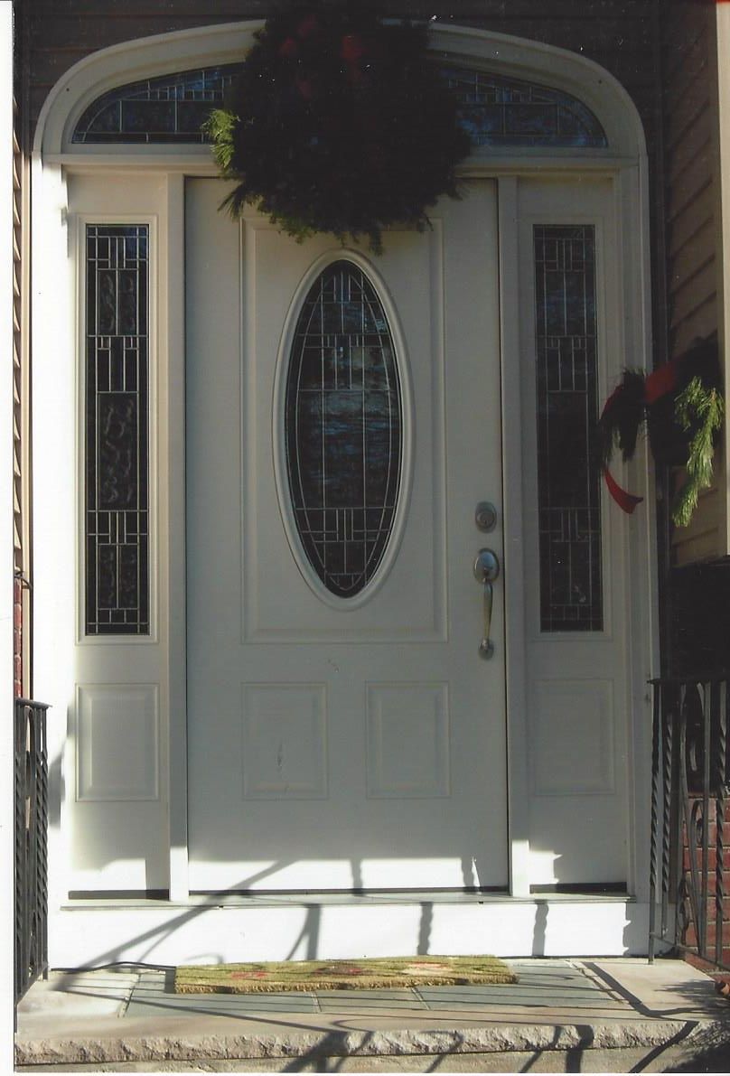 A white door with a wreath on top of it