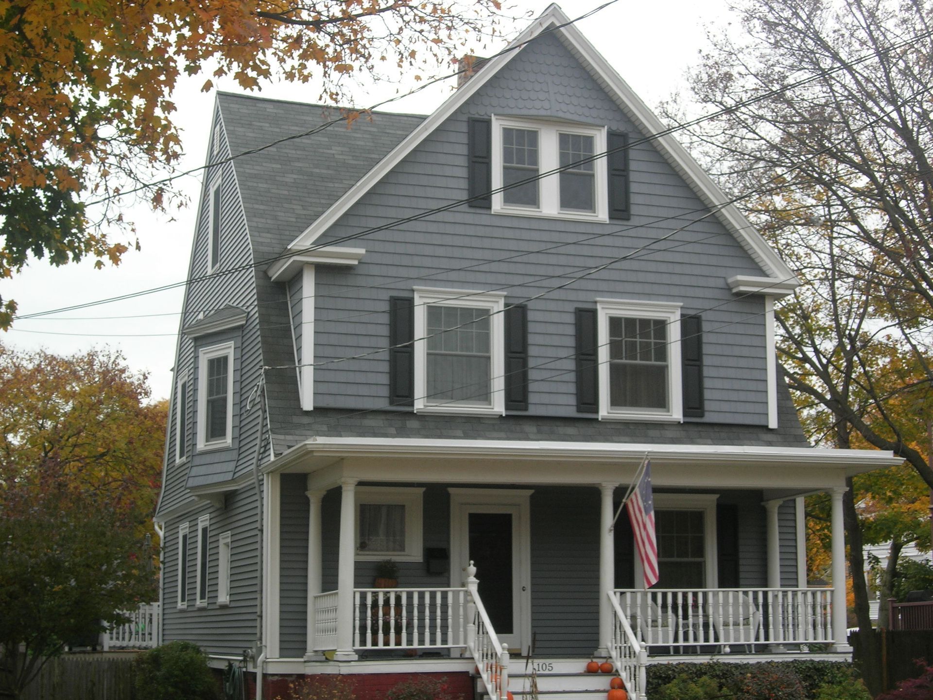 A house with a large porch and a flag on it