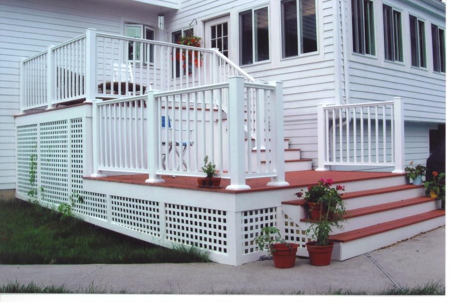 A white house with a white deck and stairs