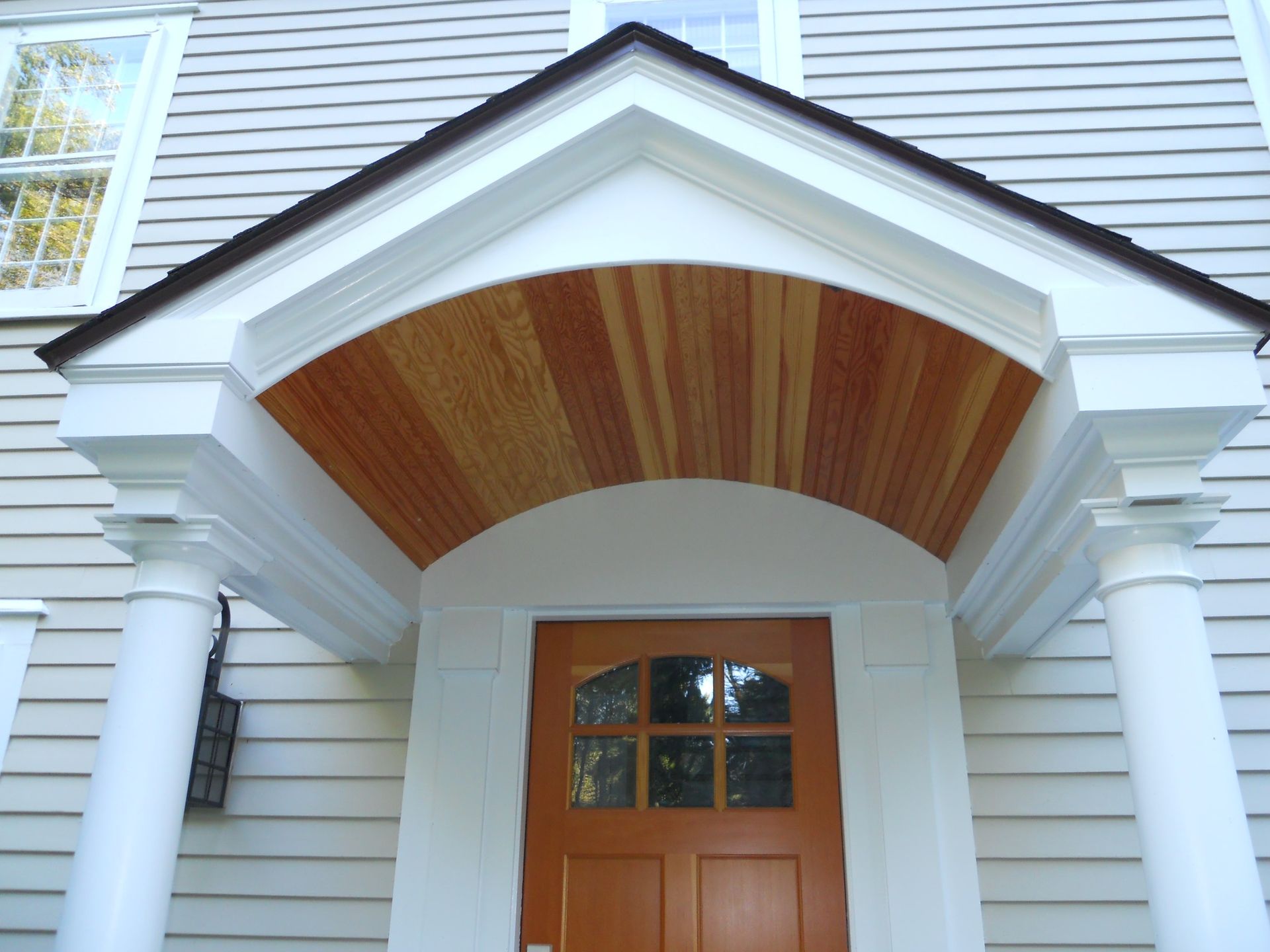 The front door of a house has a wooden canopy over it
