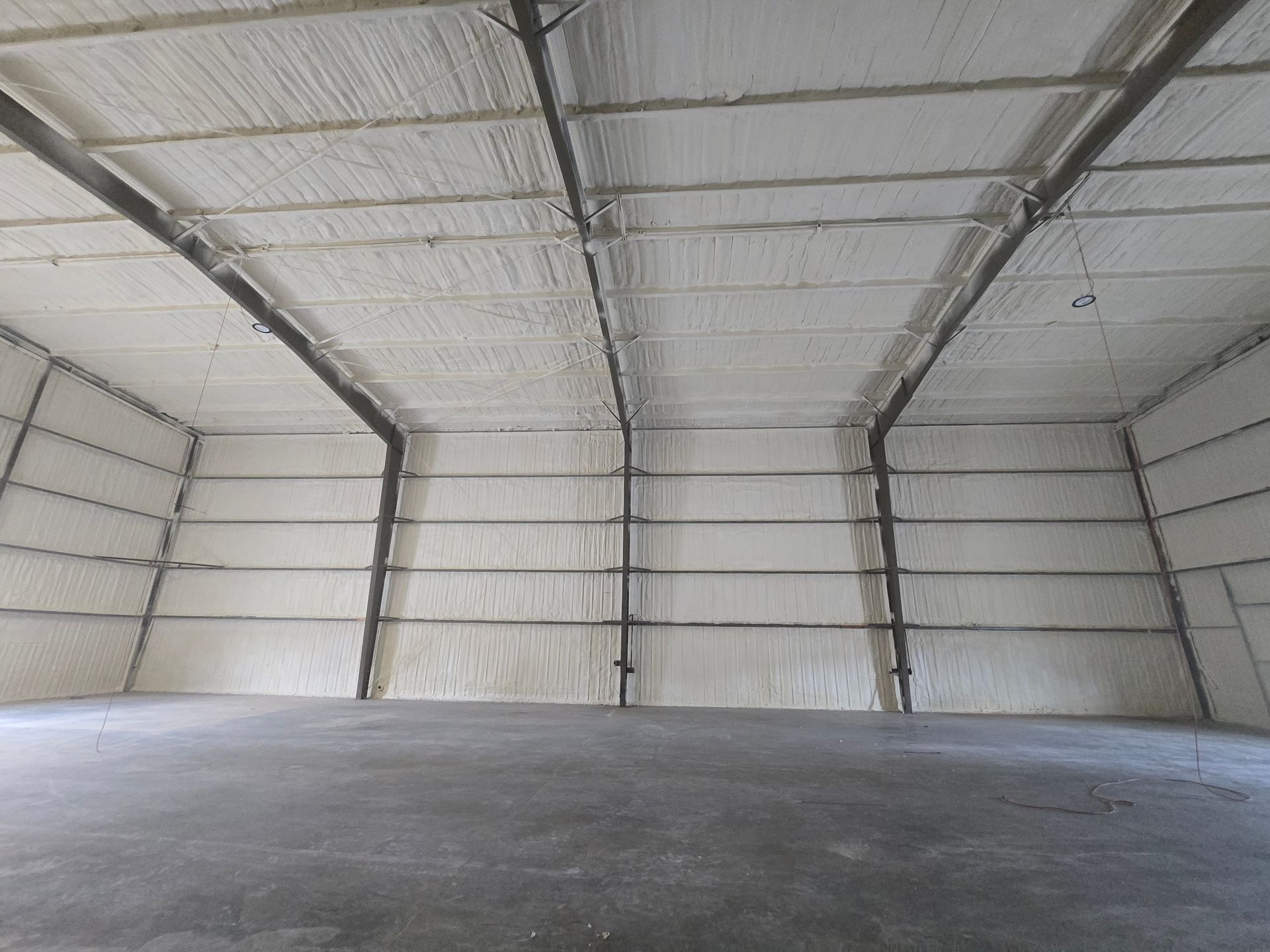 Interior of a large building with spray foam insulation on walls and ceiling.