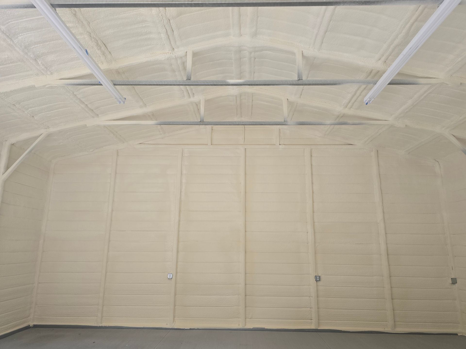 Interior of a metal building, insulated with light-colored foam.