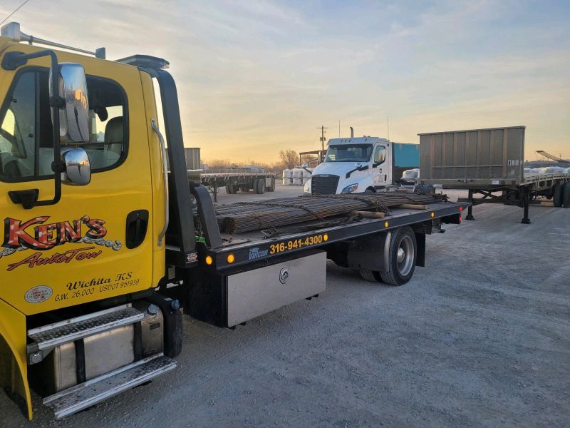 A yellow tow truck is parked in a parking lot.