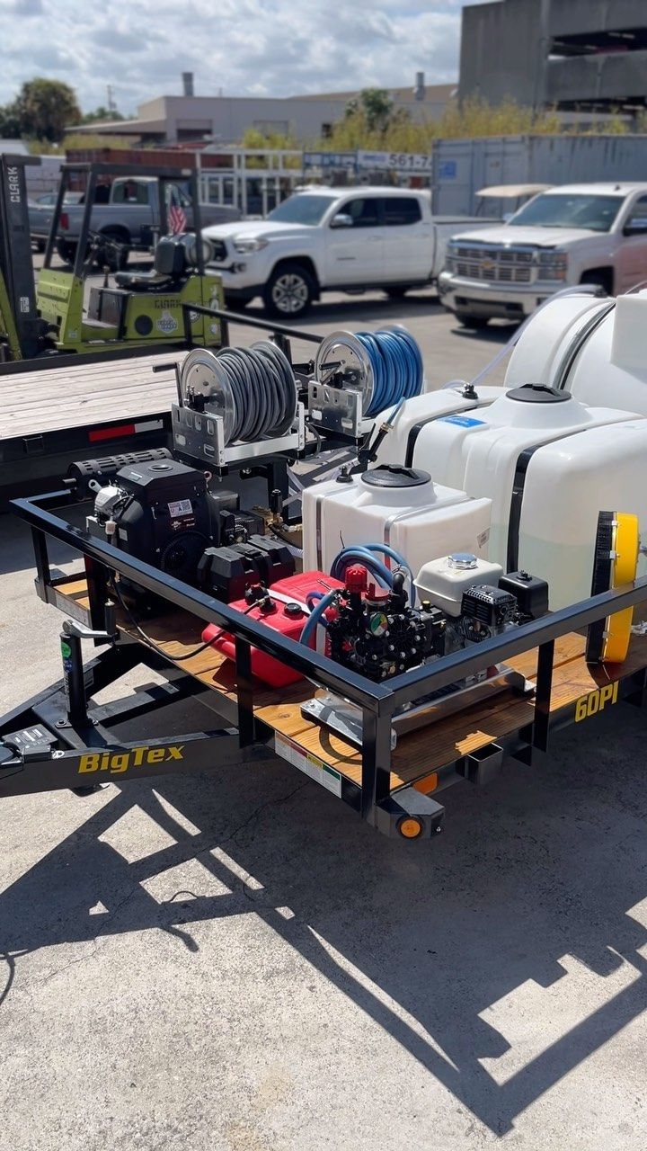 Industrial equipment mounted on a trailer in a parking lot, with white tanks and red machinery.