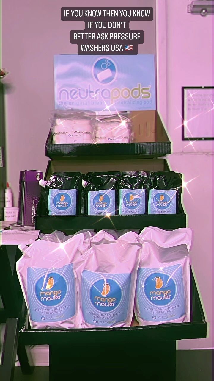 Display of blue-labeled packaged goods on shelves under a sign in a pink-lit store.