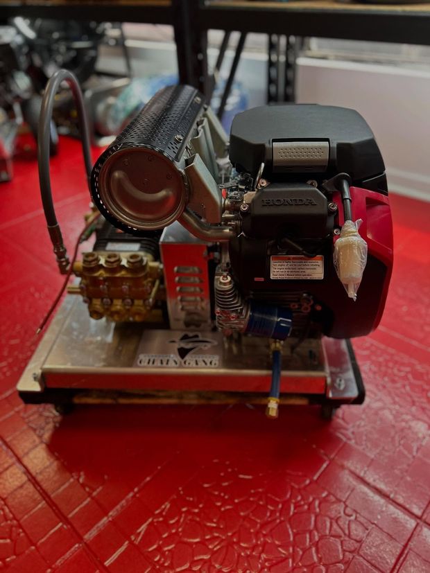 Small mechanical model with gears and a motor on a red tabletop, shown in close-up.