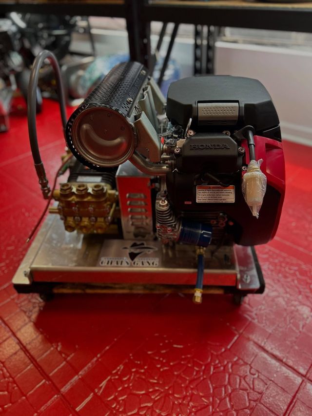 Small mechanical model with gears and a motor on a red tabletop, shown in close-up.