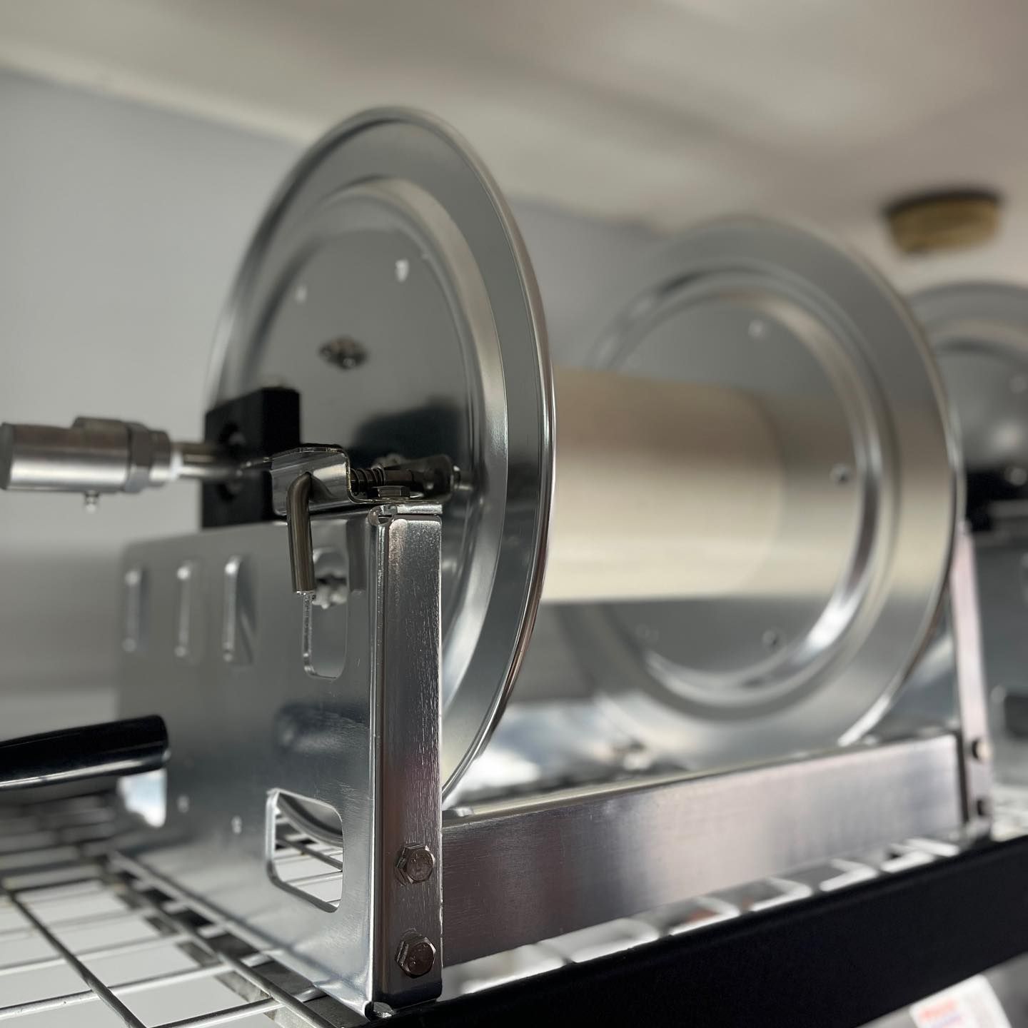 Close-up of a metal mechanical assembly with two circular disks on a rail inside a machine cabinet