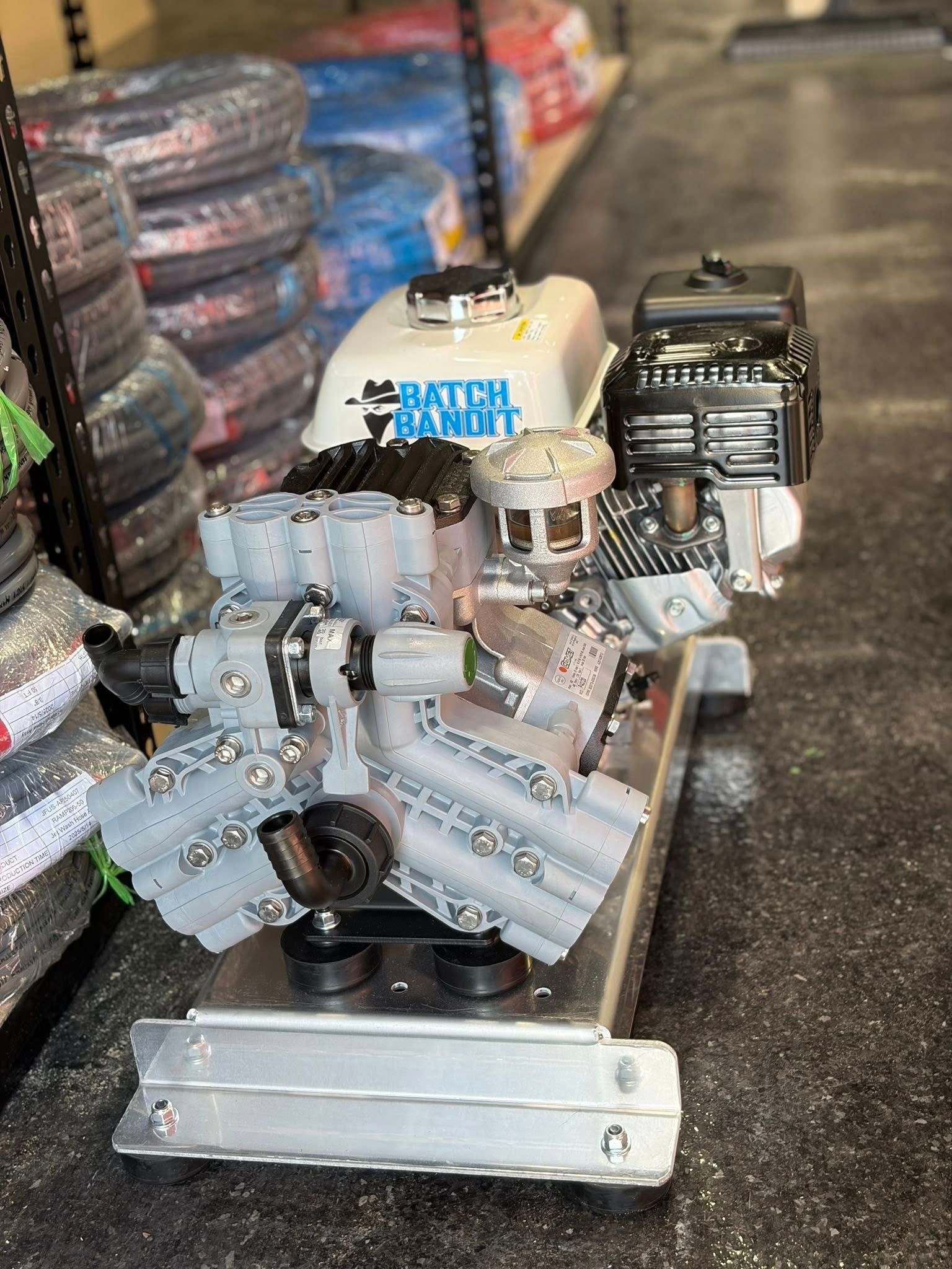 Disassembled engine parts on a pallet in a warehouse aisle, with stacked tires in the background