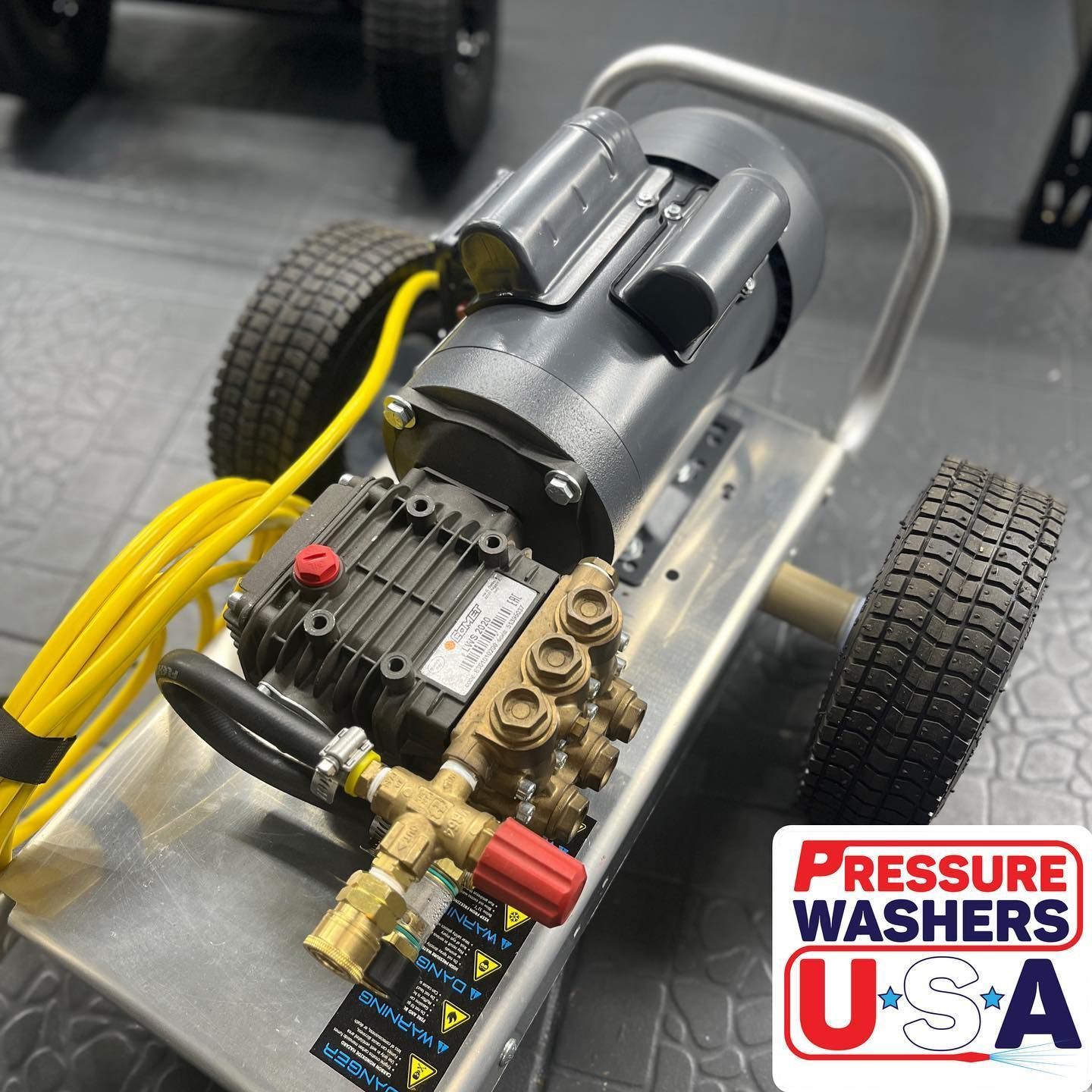 Compact pressure washer on a wheeled cart with black hose and yellow cord, Pressure Washers USA logo visible