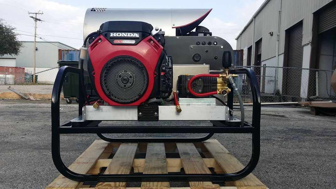 Red and black generator mounted on a pallet in an industrial yard, with a truck in the background