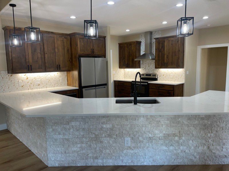 A kitchen with stainless steel appliances , wooden cabinets , and a large island.