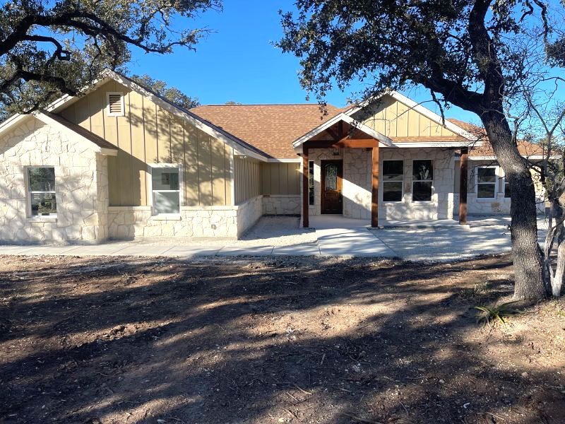 A house with a porch and a tree in front of it