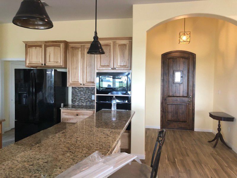A kitchen with granite counter tops and a black refrigerator