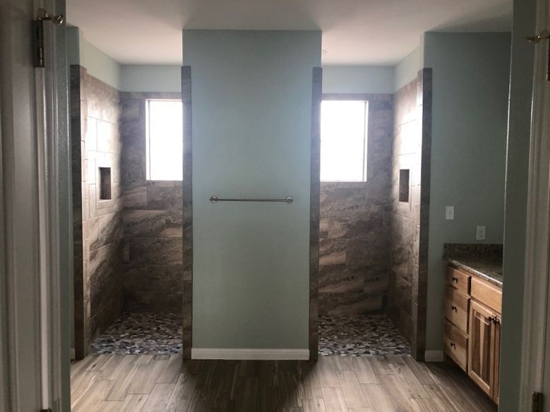 A bathroom with two walk in showers and a sink.