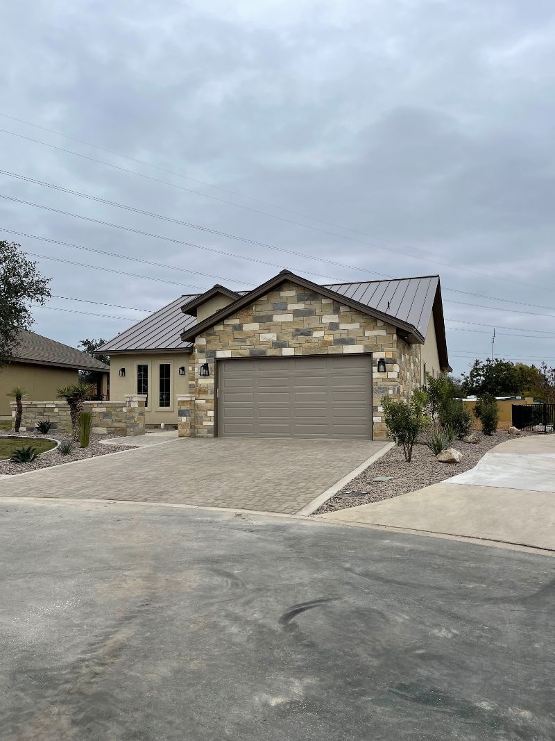 A house with a garage and a driveway in front of it.