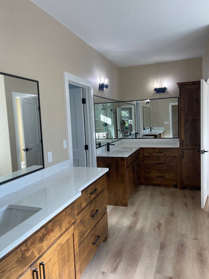 A bathroom with two sinks and a large mirror.