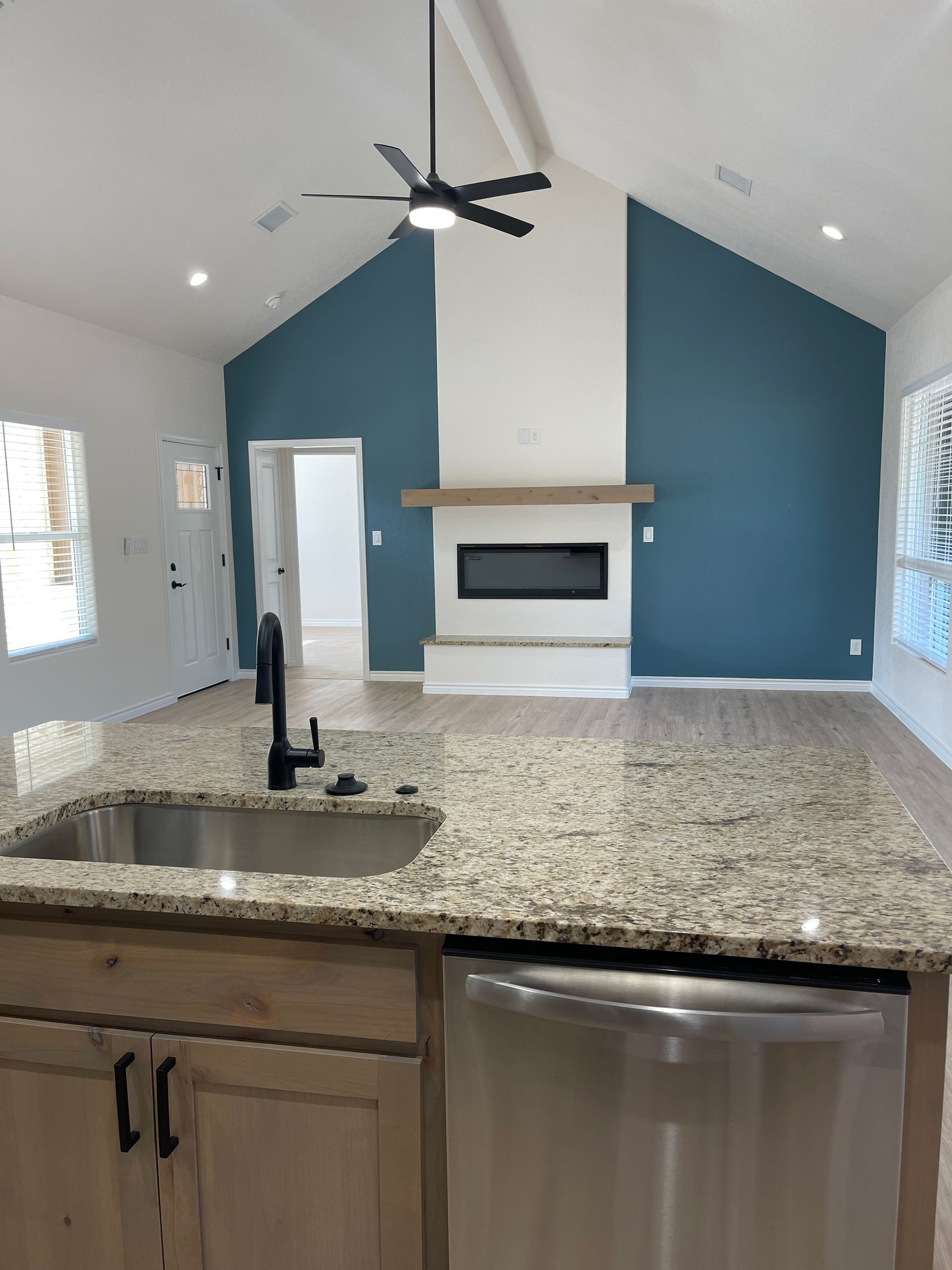 A kitchen with granite counter tops and a ceiling fan