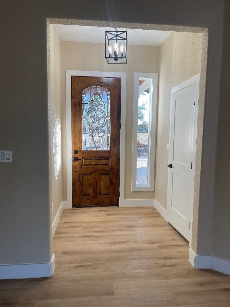 A hallway with a wooden door and a stained glass window