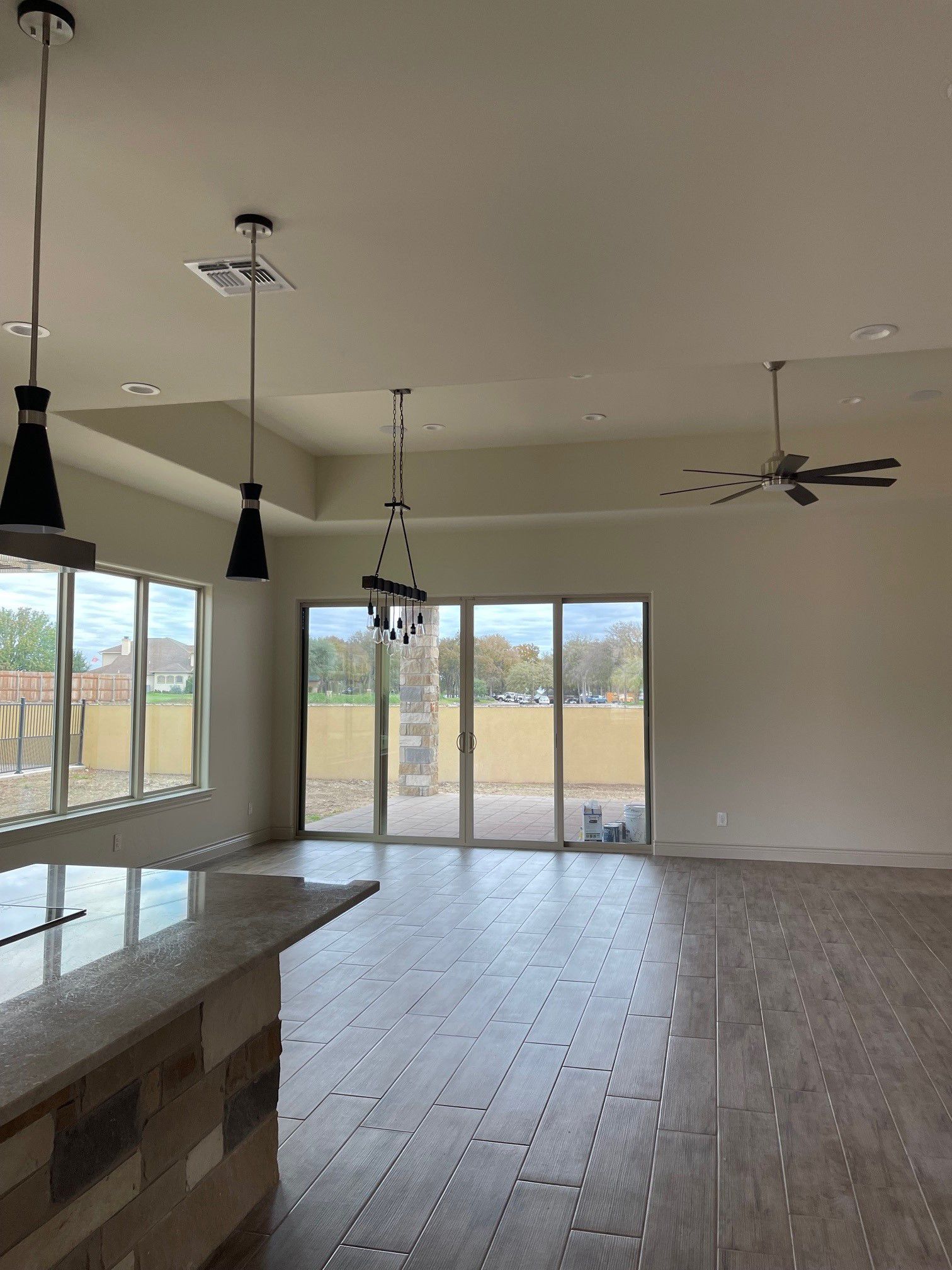 An empty room with a lot of windows and a ceiling fan