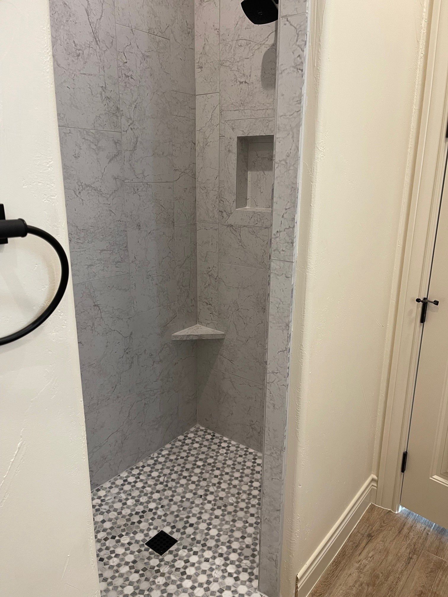 A bathroom with a walk in shower and a towel rack.