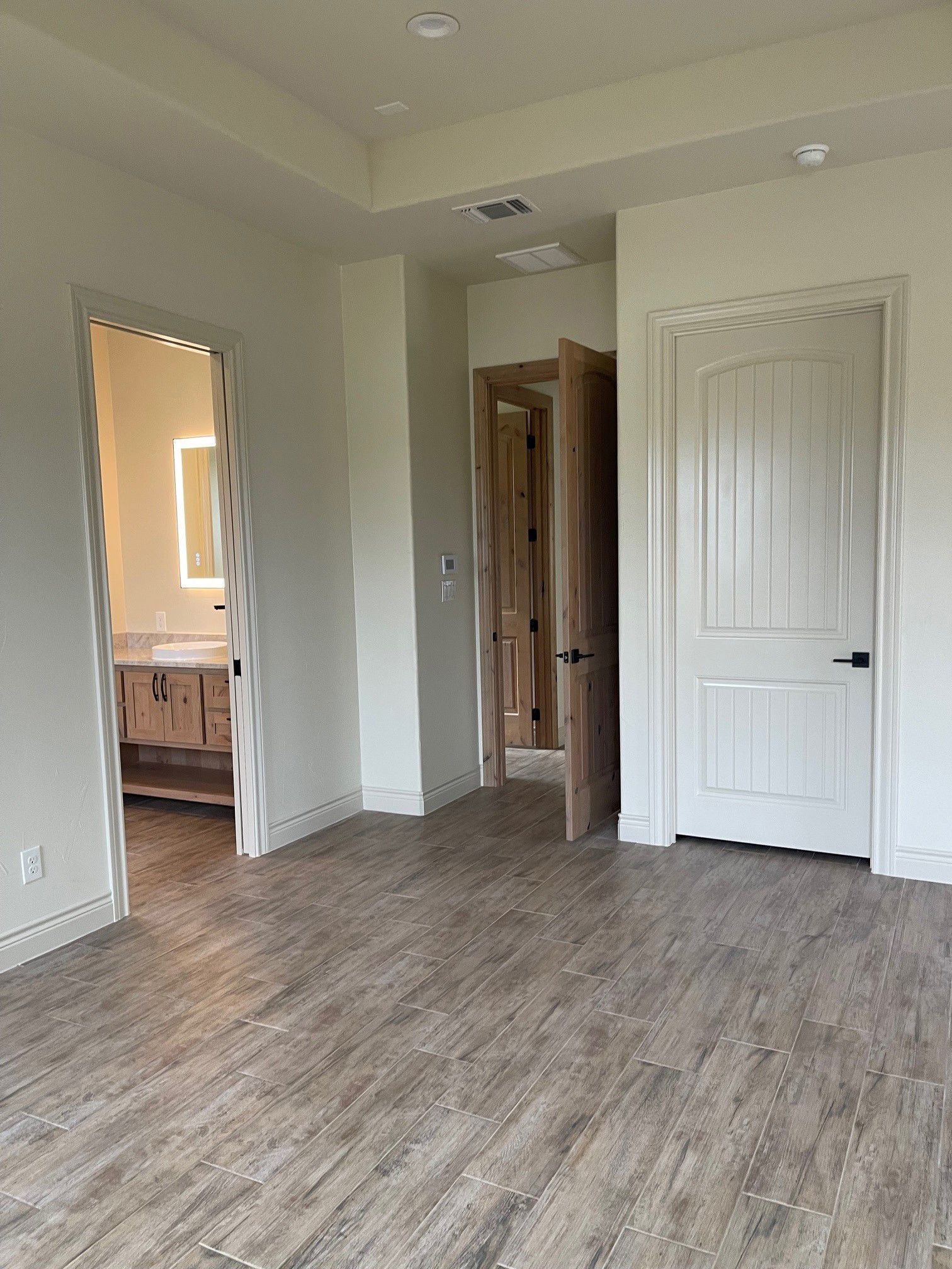 A large empty room with wooden floors and white walls.