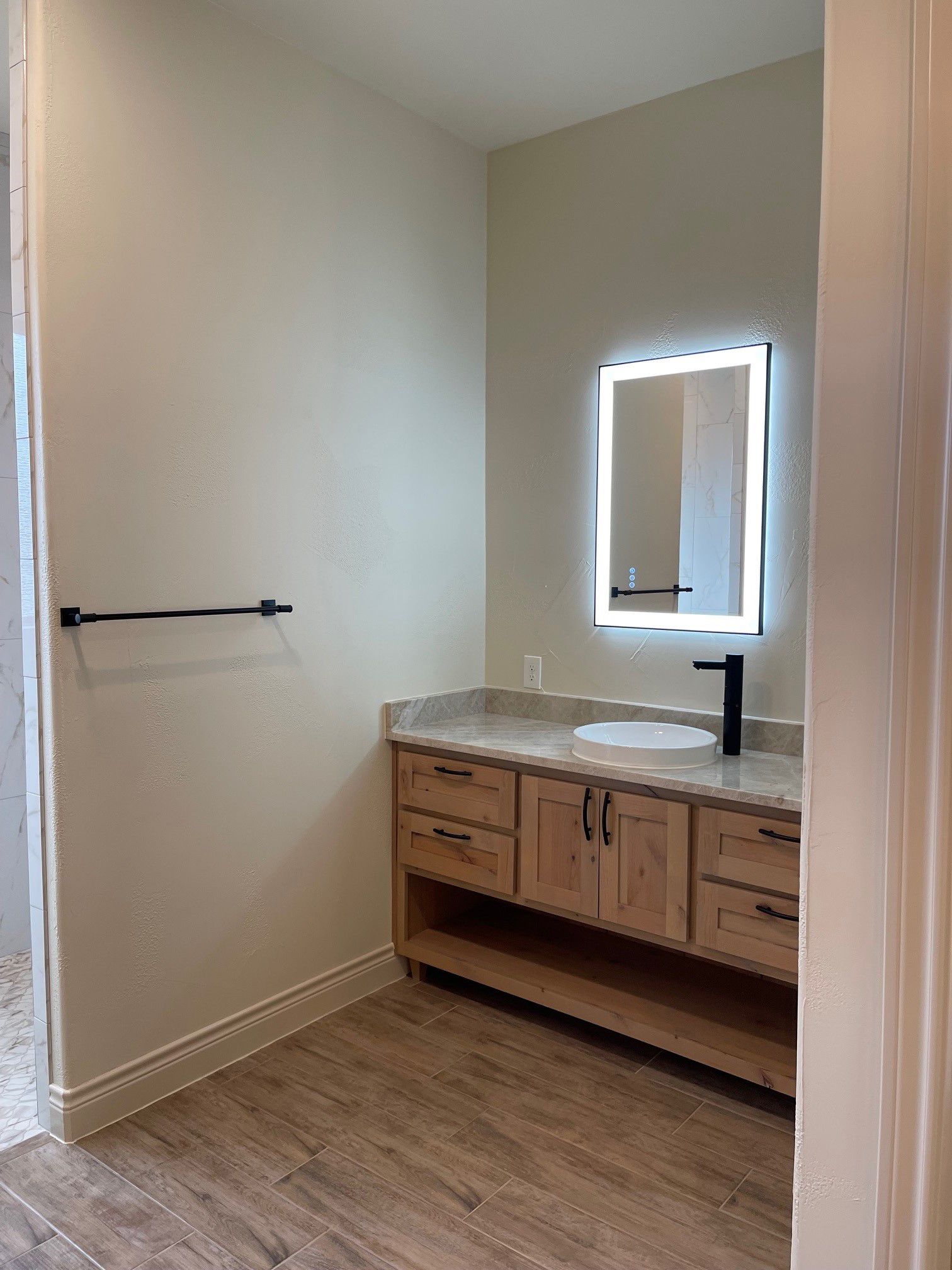 A bathroom with a sink , mirror and towel rack.