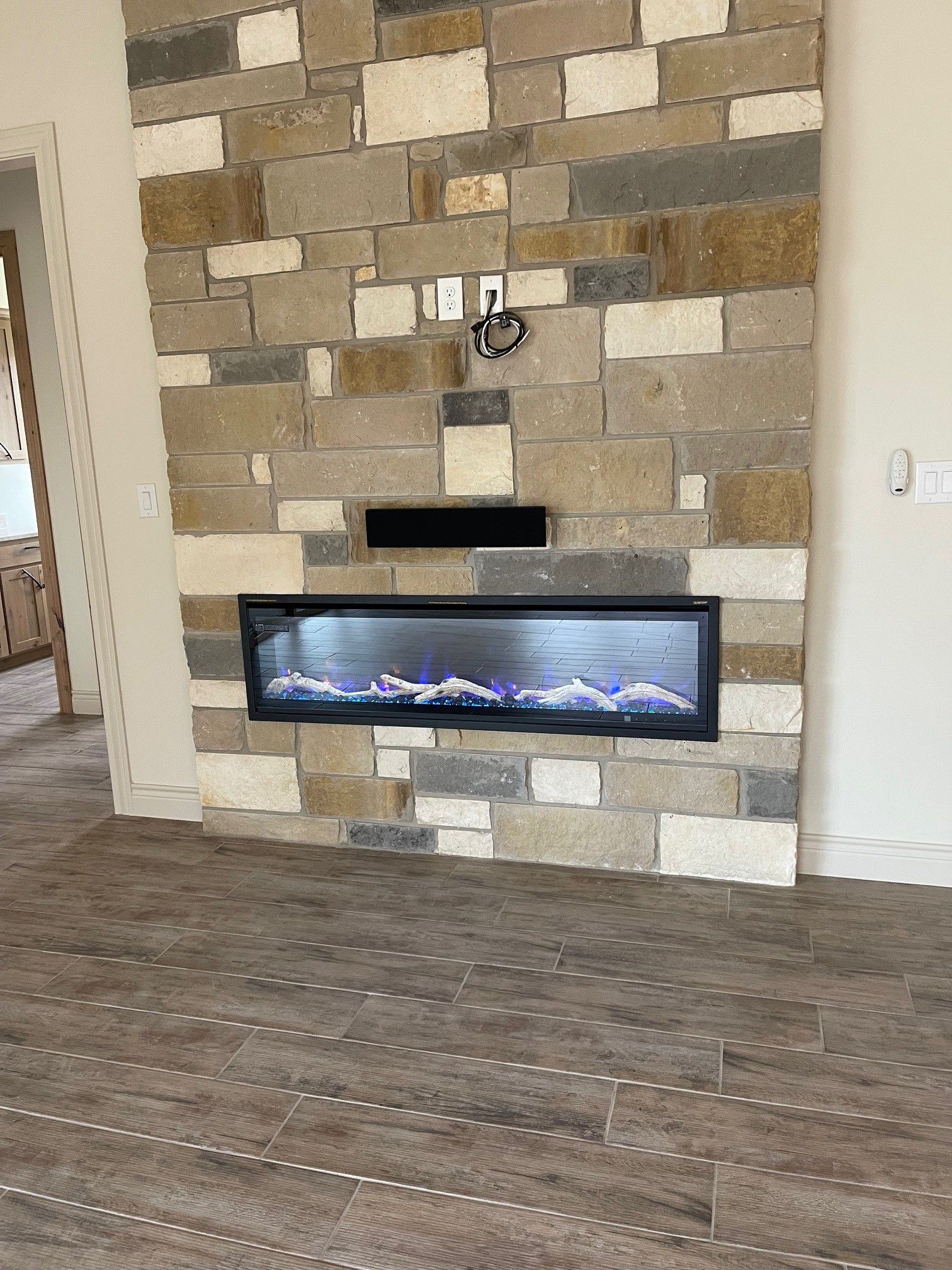 A fireplace is built into a stone wall in a living room.
