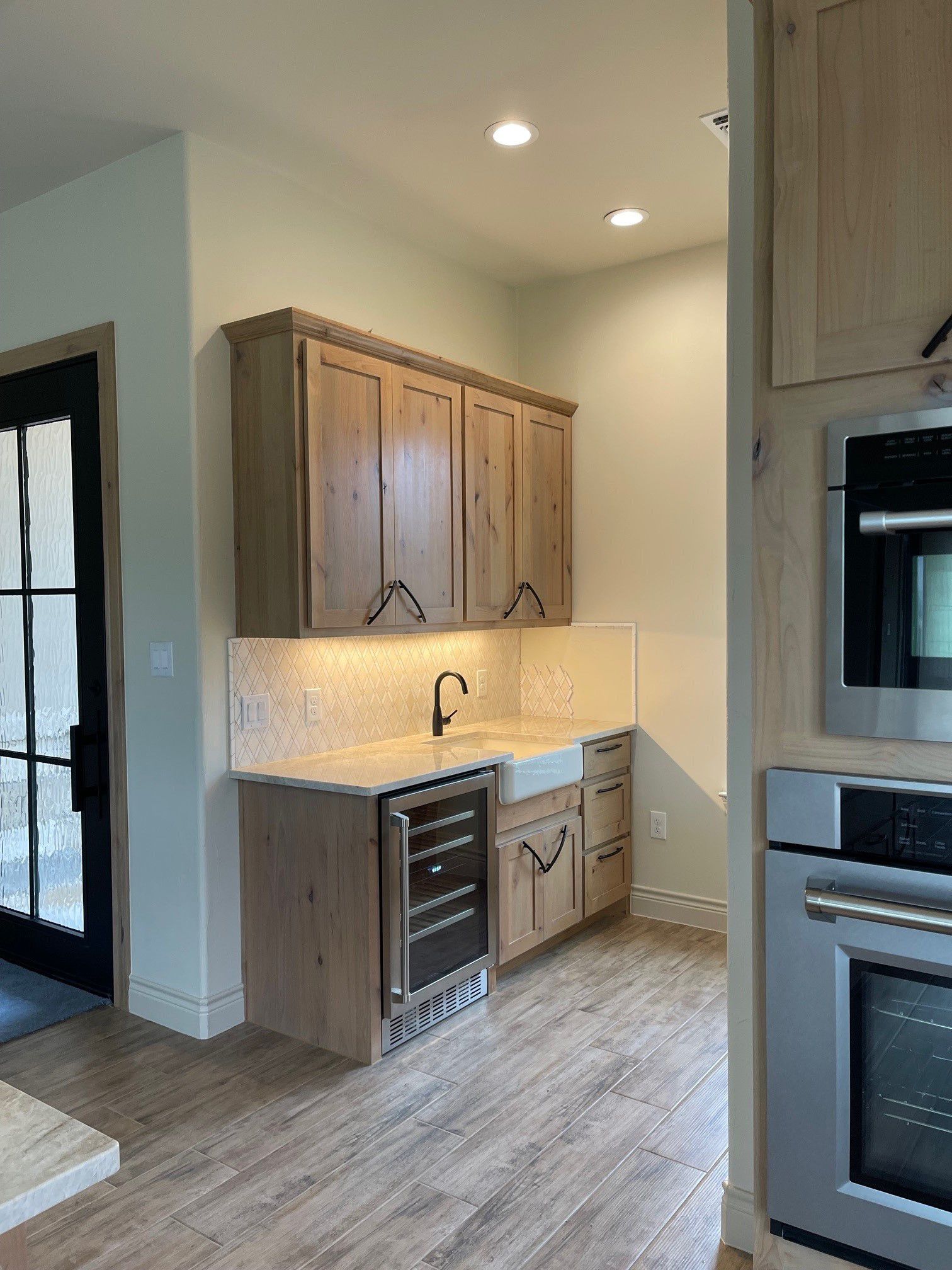 A kitchen with wooden cabinets , stainless steel appliances , and a sink.