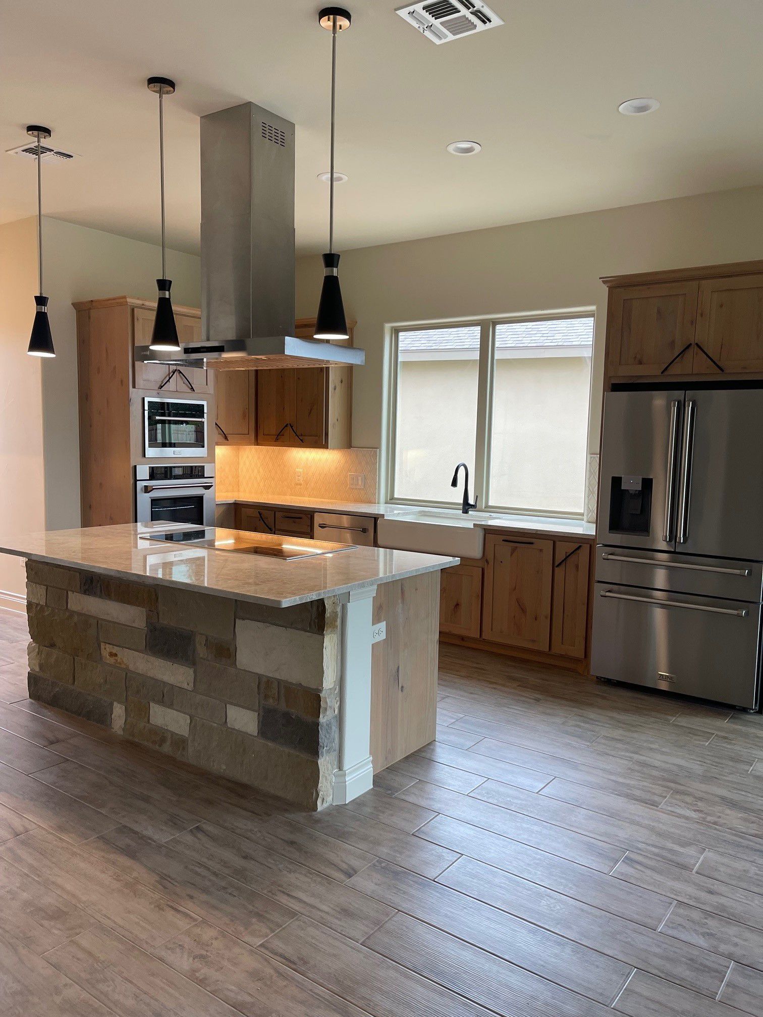 A kitchen with stainless steel appliances and a large island.