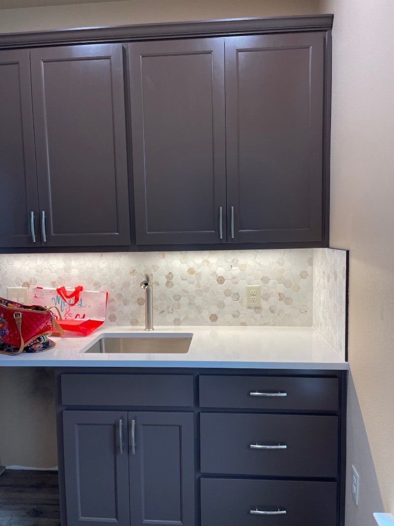 A kitchen with a sink , cabinets and drawers.