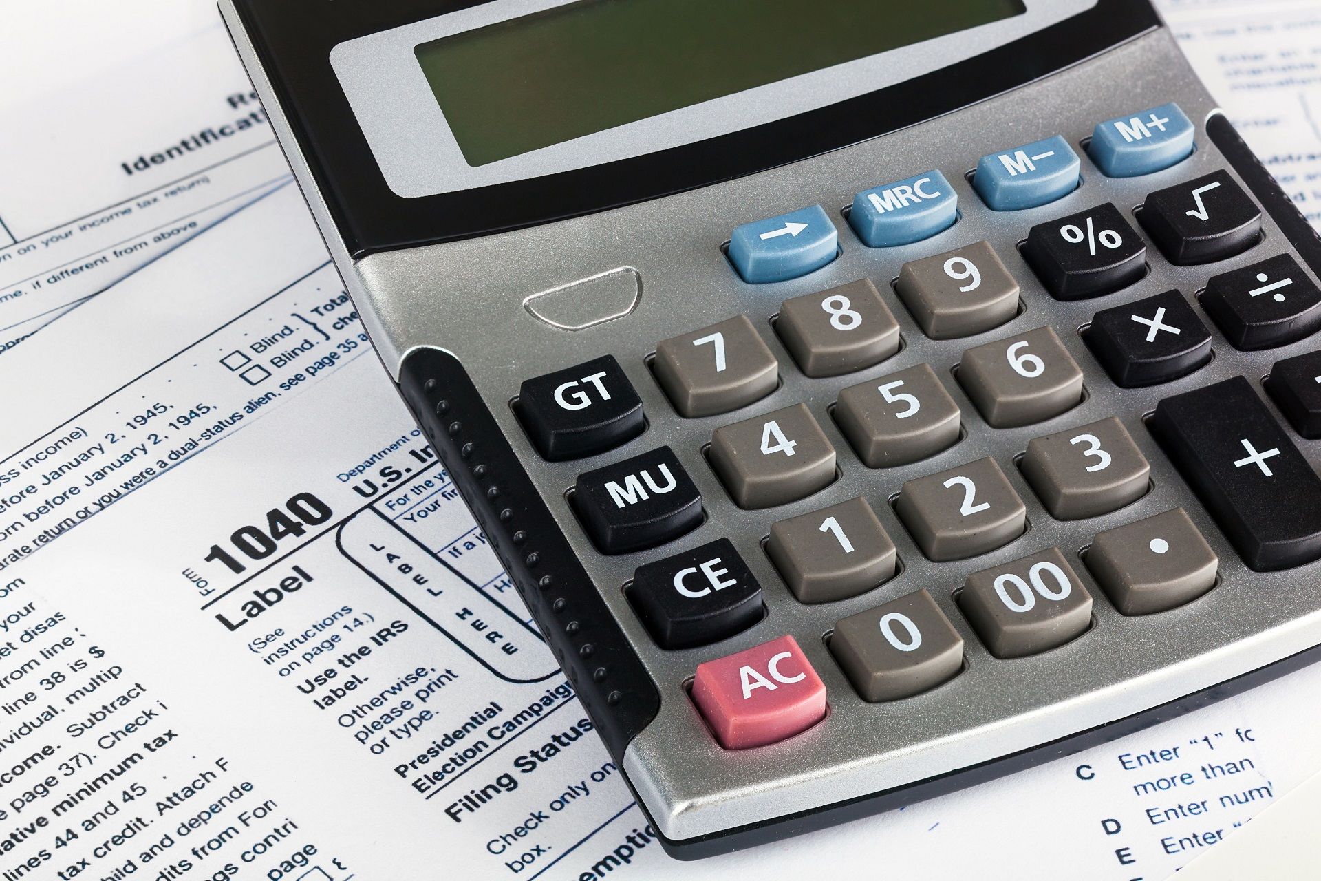 A calculator is sitting on top of a 1040 tax form
