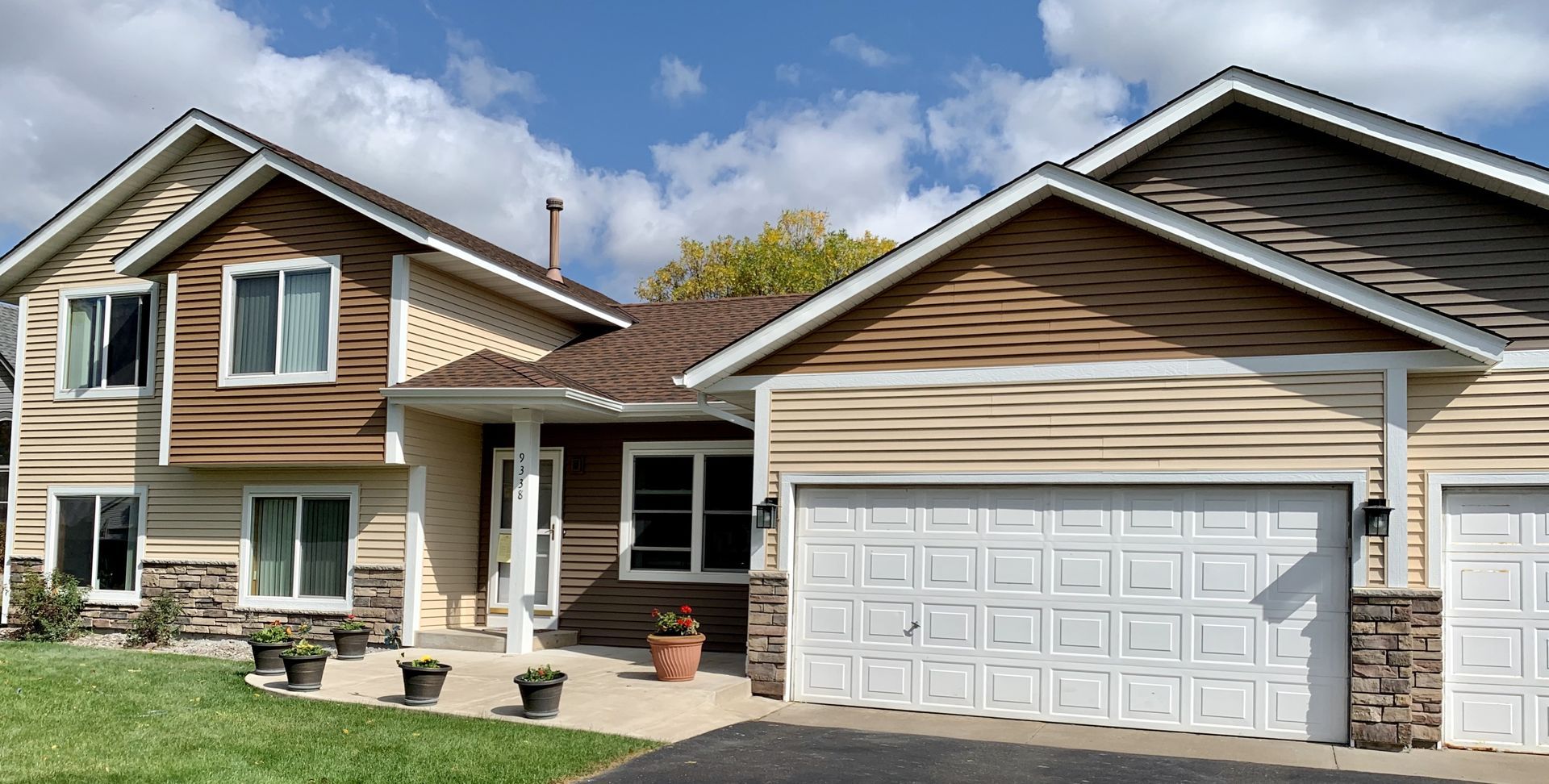 A large house with two garage doors and a lot of windows.