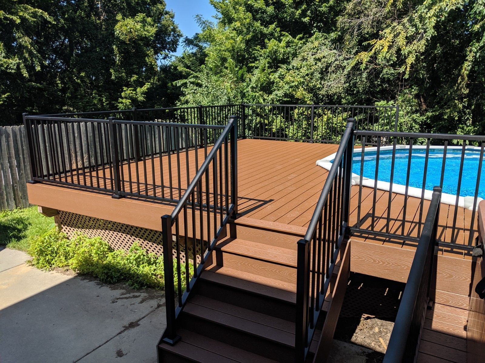 A wooden deck with stairs leading to a swimming pool