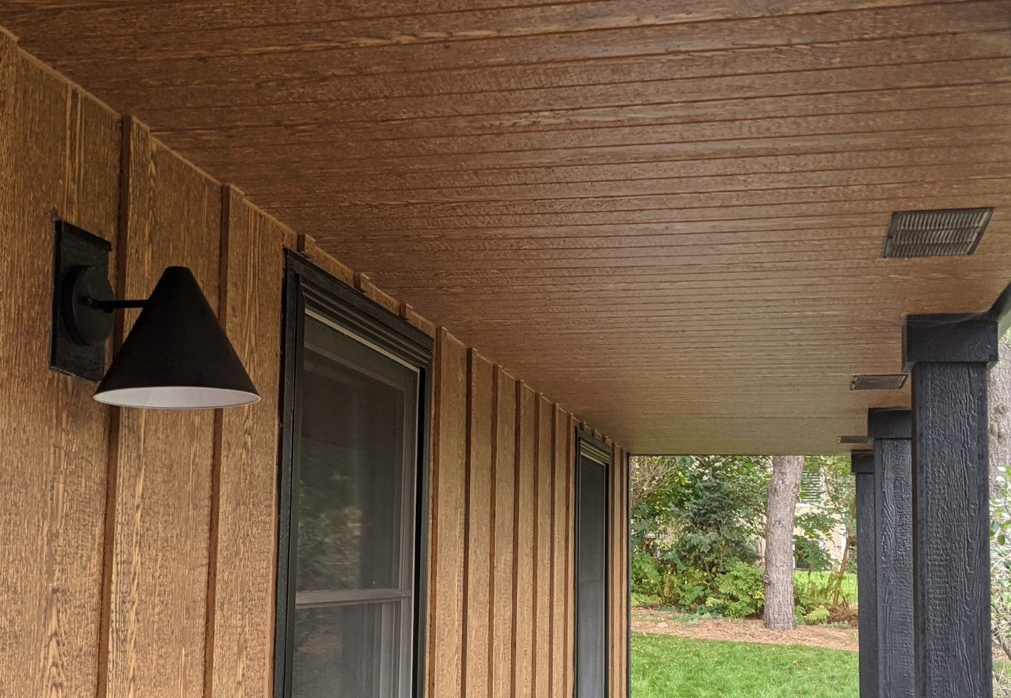 A porch with a light on the side of it