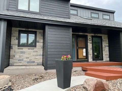 A house with two garbage cans in front of it.