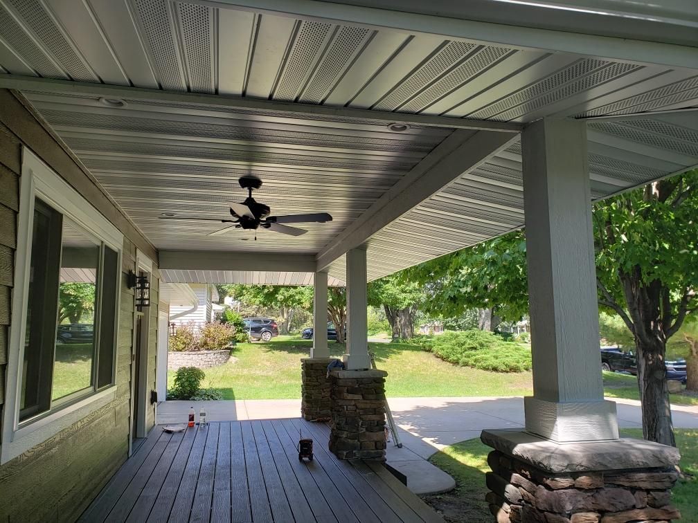There is a ceiling fan on the porch of a house.