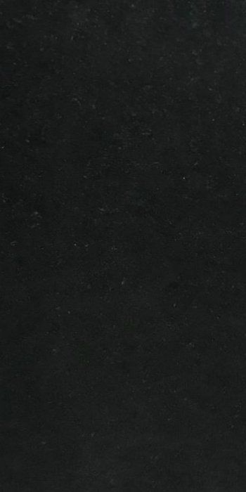 A close up of a black surface with a grainy texture.